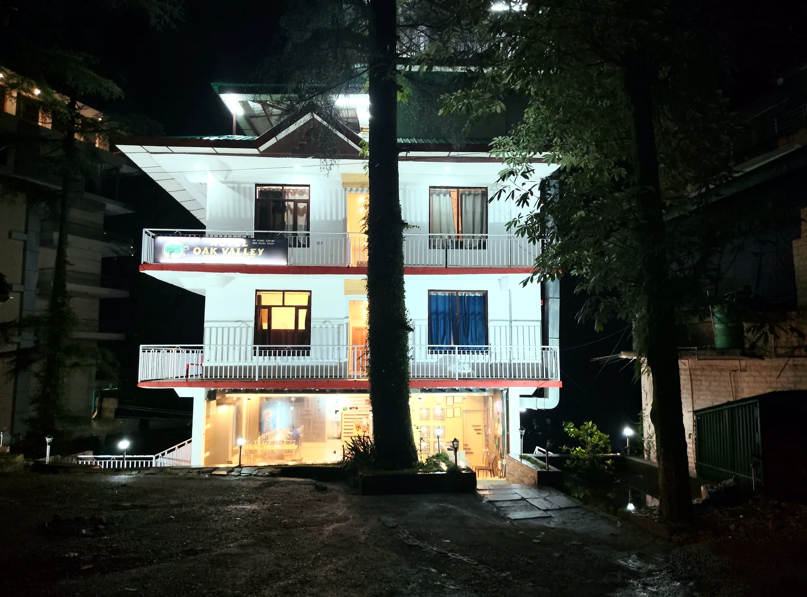 Hotel The Oak Valley lit up at night among the deodars